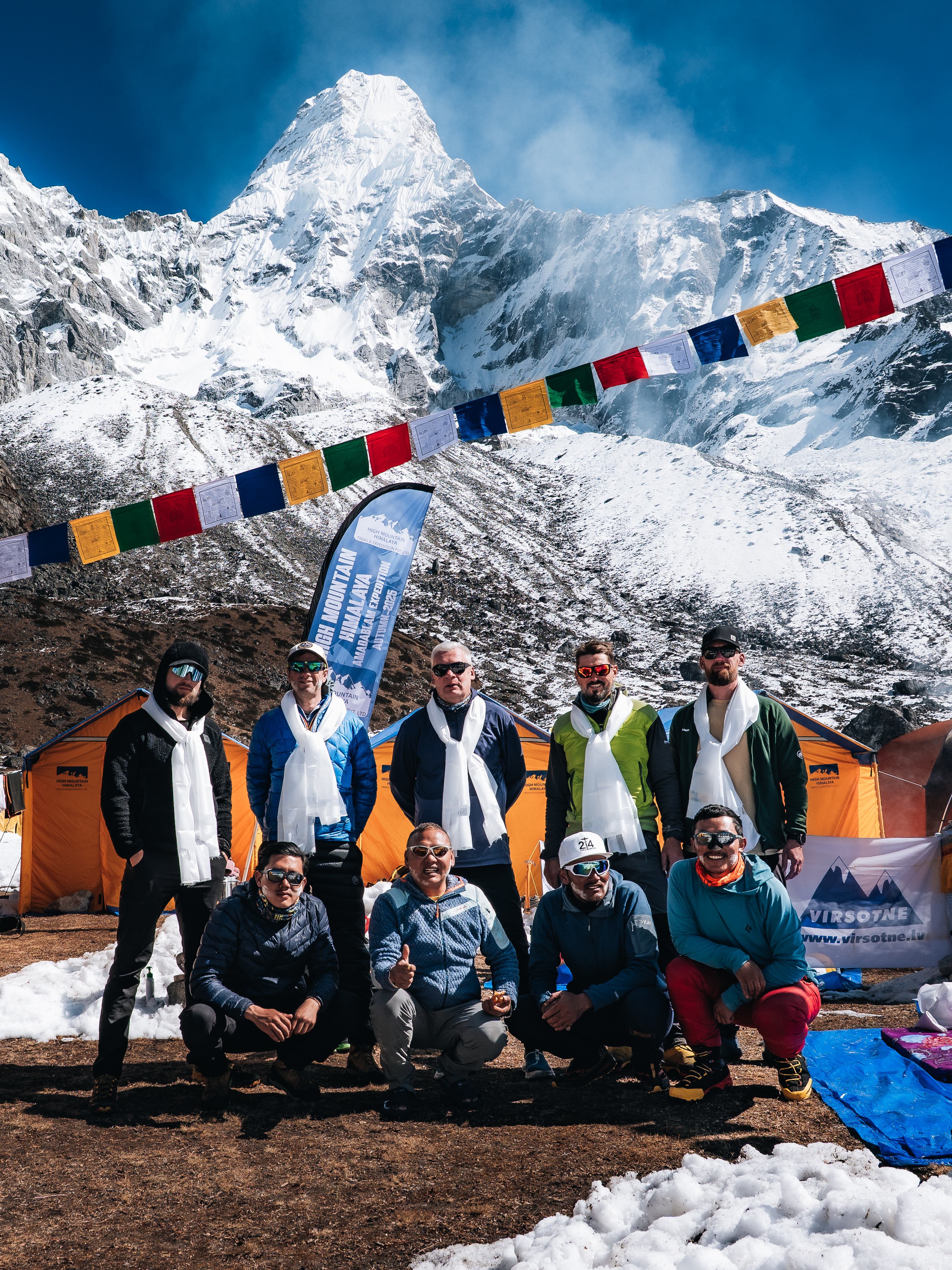 Komanda bāzes nometnē kalnu fonā